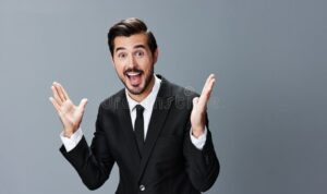 man-business-suit-surprised-smiling-smile-his-teeth-raising-hands-up-against-gray-262666439.jpg