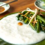 Resep Jenang Pecel Khas Boyolali, Bubur Sumsum Bersiram Sambal Kacang Ilustrasi bubur putih dengan sayur rebus dan sambal kacang di atas daun pisang