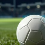 Ilustrasi bola sepak putih di atas rumput lapangan pada malam hari