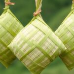 Ilustrasi tiga ketupat anyaman janur hijau yang digantung