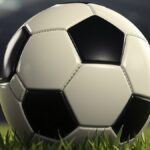 Ilustrasi bola sepak hitam putih di atas rumput stadion