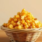 Marning Jagung, Camilan Renyah yang Jadi Oleh-oleh Khas Boyolali Ilustrasi butiran jagung goreng renyah berwarna keemasan di dalam keranjang bambu